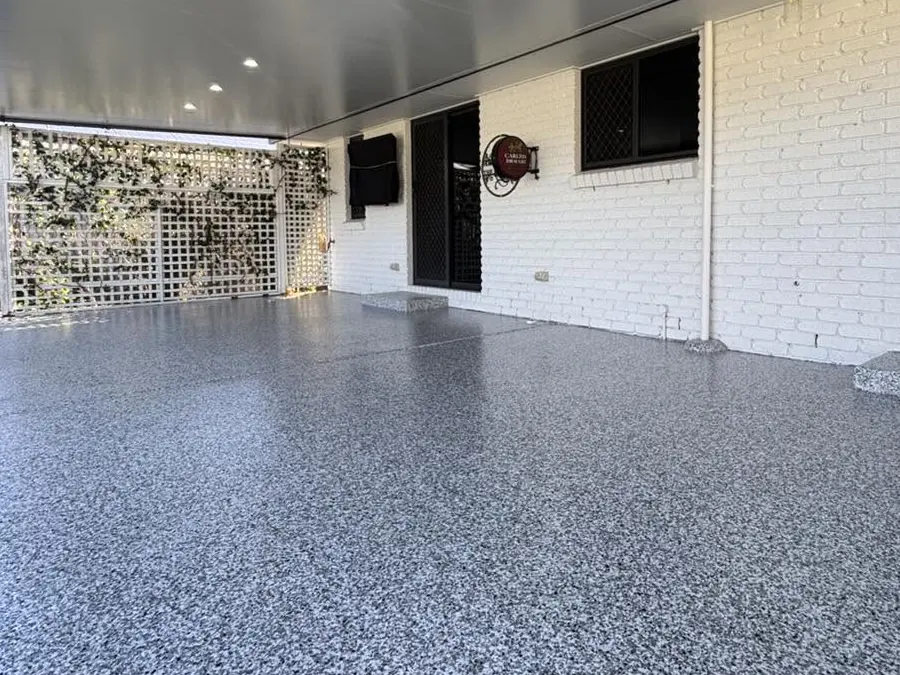 The same undercover patio after: a grey epoxy flake floor from the lattice screen to the back door