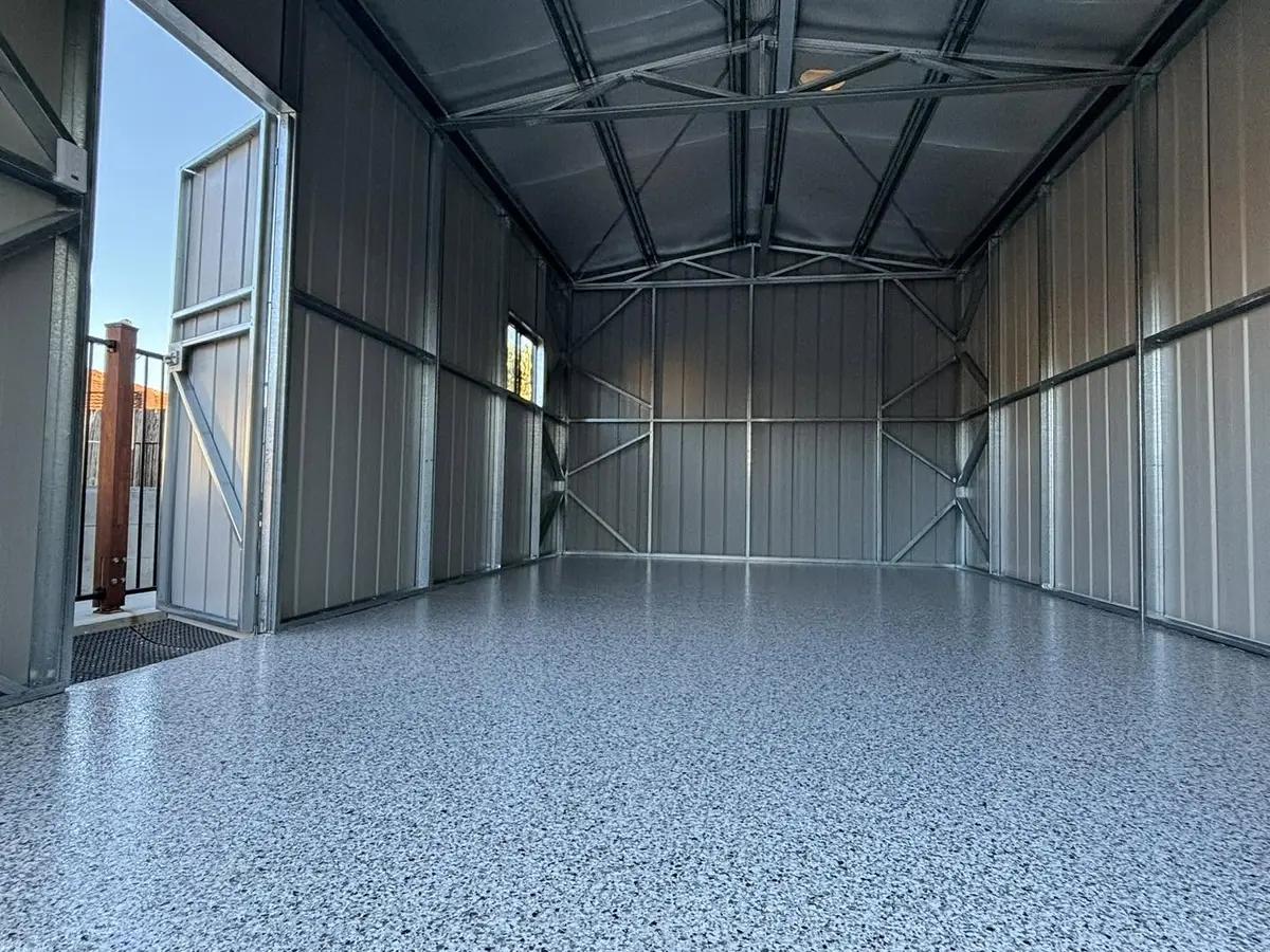 Inside a new steel shed, the concrete floor finished wall to wall in grey epoxy flake